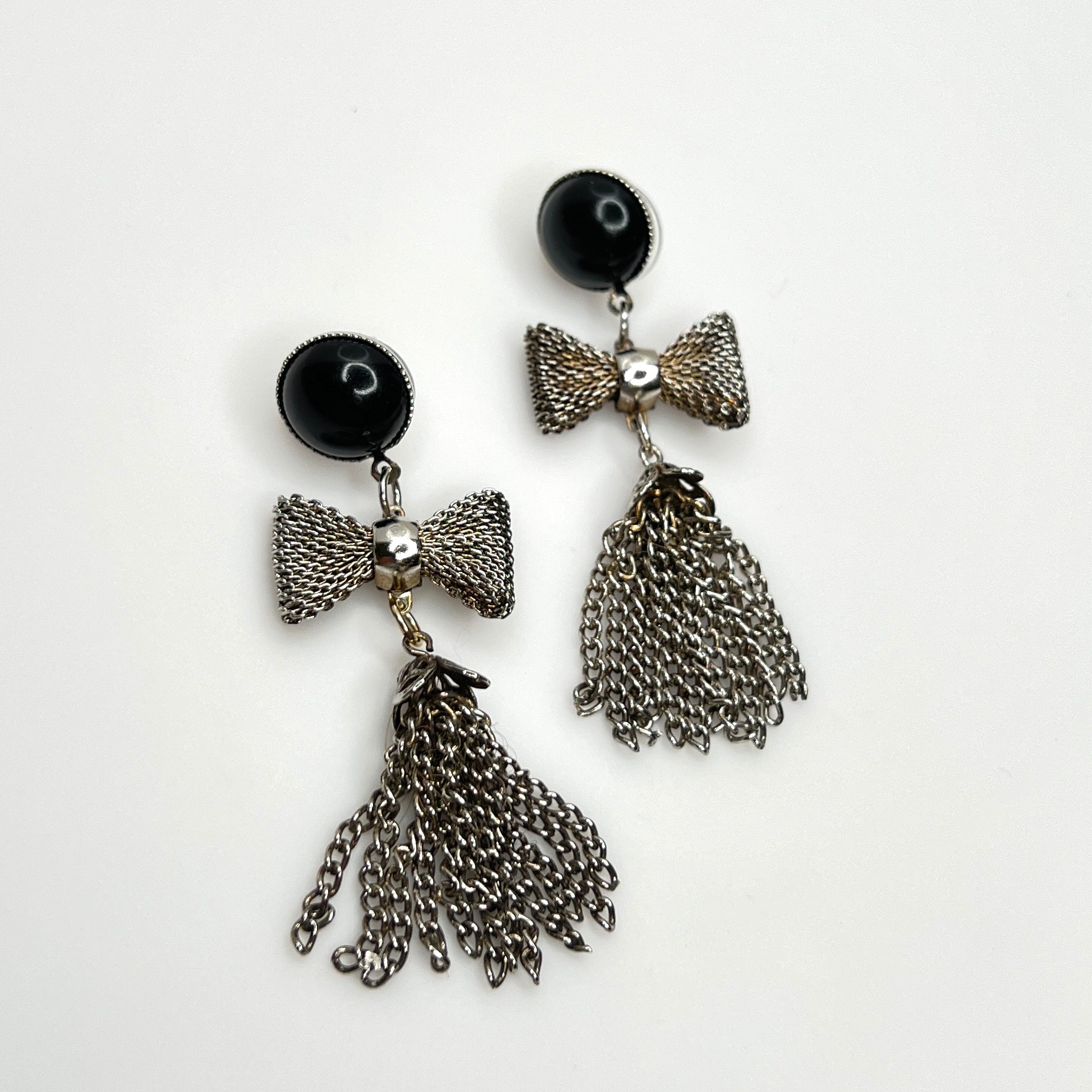 Vintage 1970s silver tone mesh bow earrings with chain tassel dangles and black acrylic studs