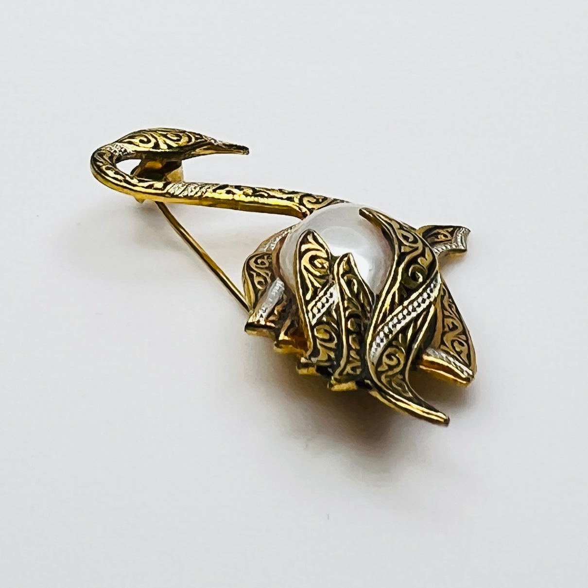 Side view of vintage swan brooch with faux pearl cabochon center