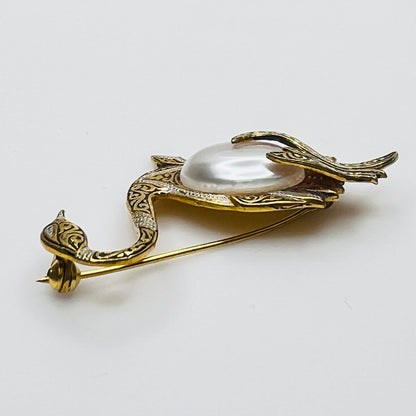 Side view of vintage swan brooch with faux pearl cabochon center
