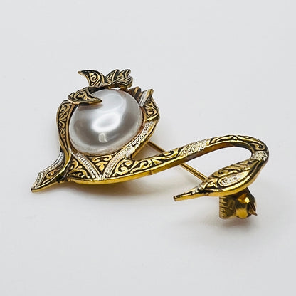 Side view of vintage swan brooch with faux pearl cabochon center