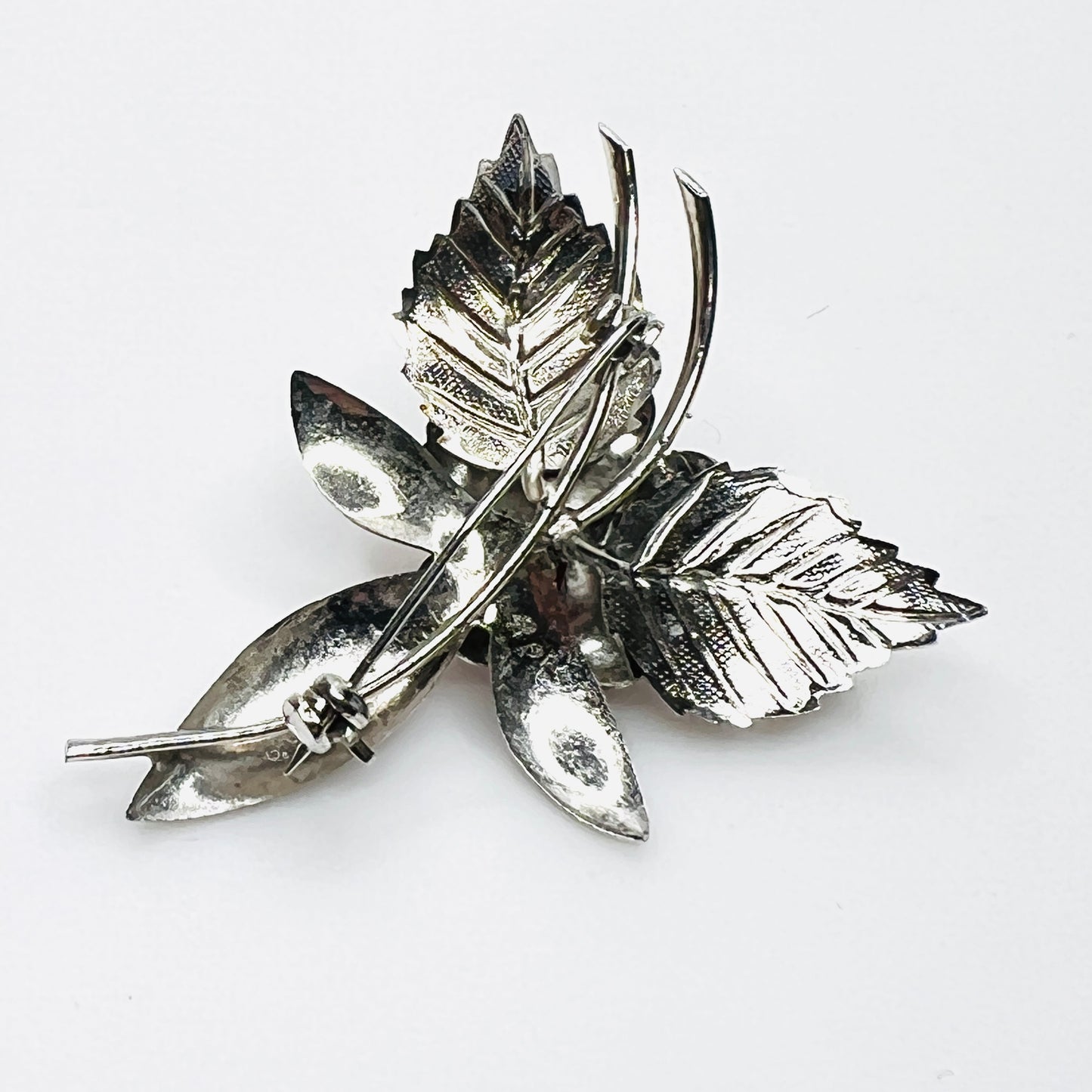 Back view of vintage 1970s stainless steel floral brooch with pin clasp