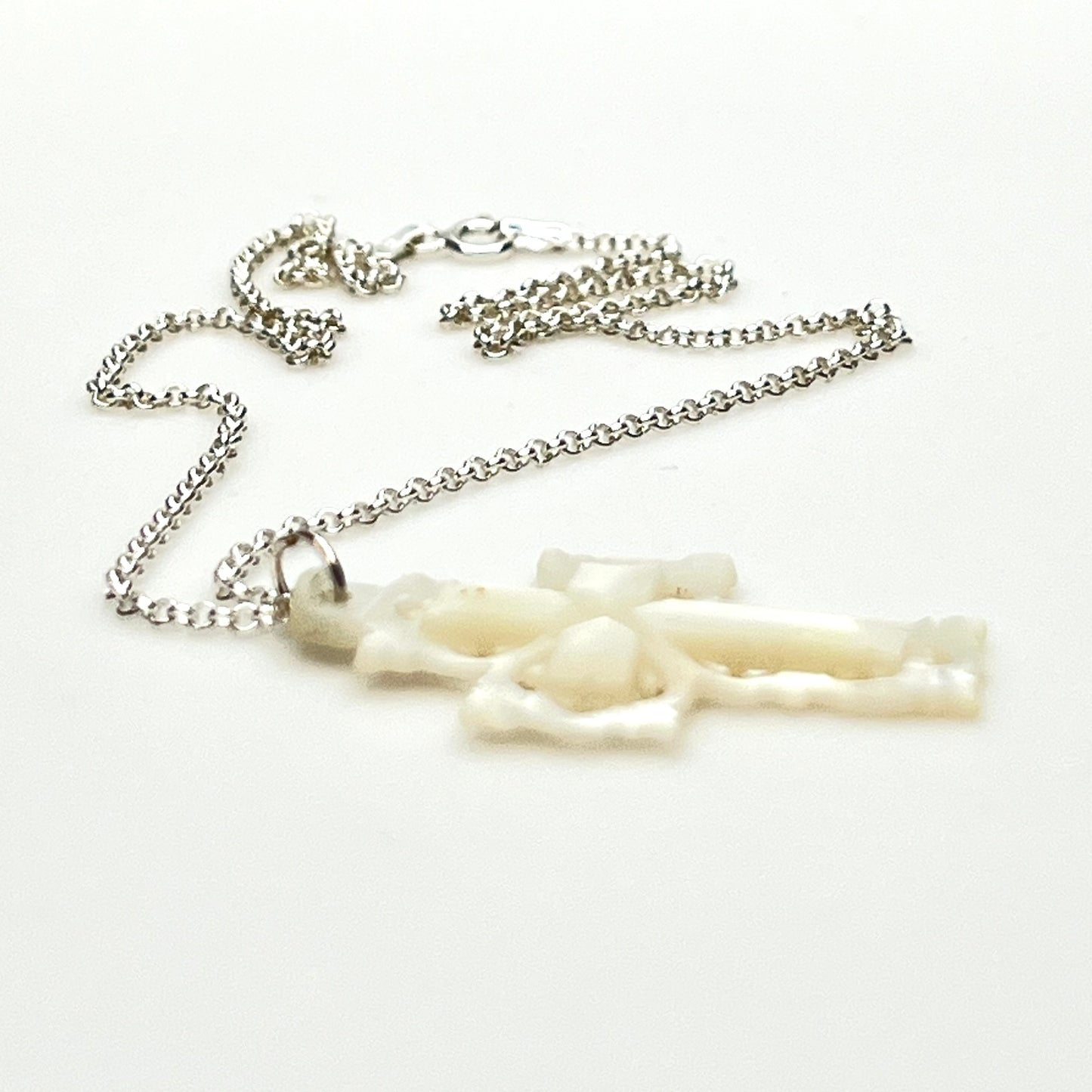 Side profile of vintage Mother of Pearl cross pendant on sterling silver chain.