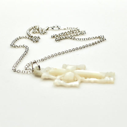 Side profile of vintage Mother of Pearl cross pendant on sterling silver chain.