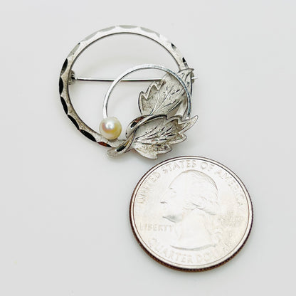 DCE sterling silver pearl brooch shown beside quarter for scale