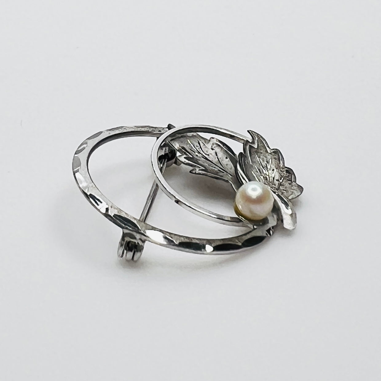 Side view of sterling silver pearl brooch with sculpted leaves