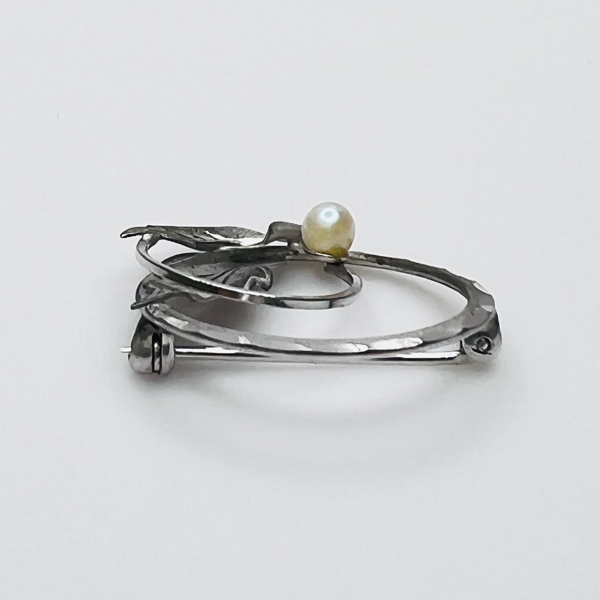 Side view of sterling silver pearl brooch with sculpted leaves