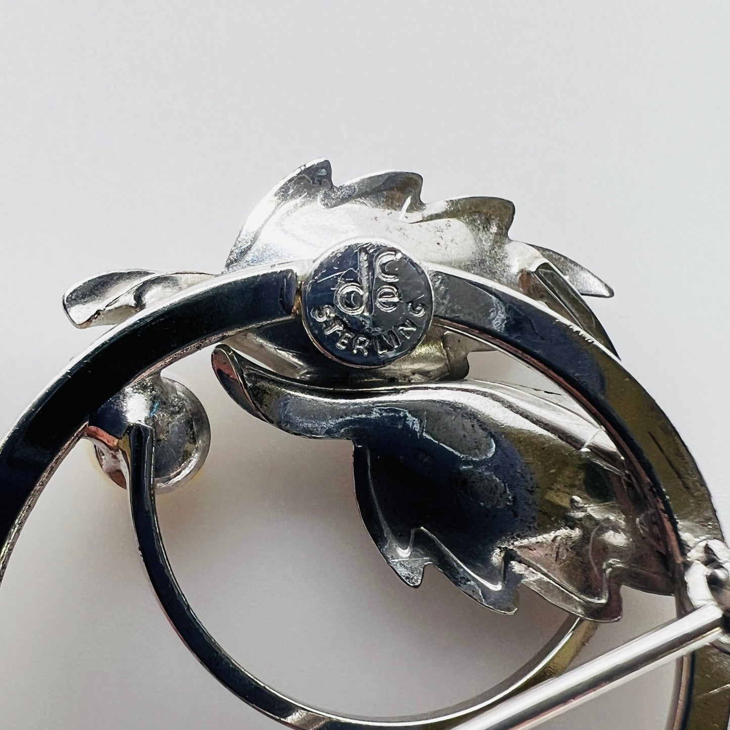 Close-up of DCE Curtis Jewelry sterling hallmark on brooch