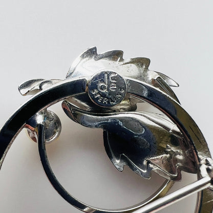 Close-up of DCE Curtis Jewelry sterling hallmark on brooch