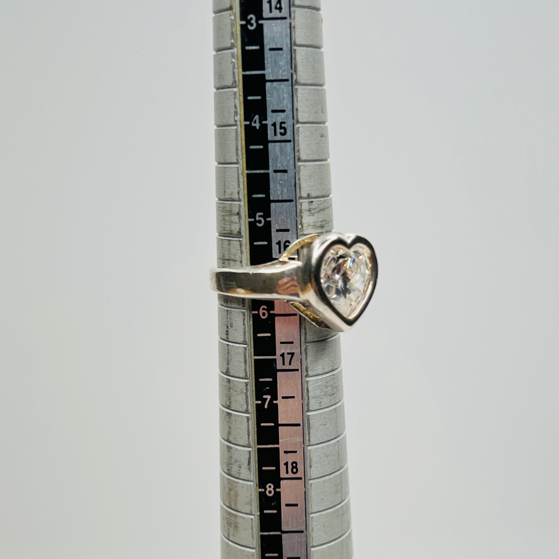 Close-up of heart-shaped CZ stone in silver setting on ring sizer