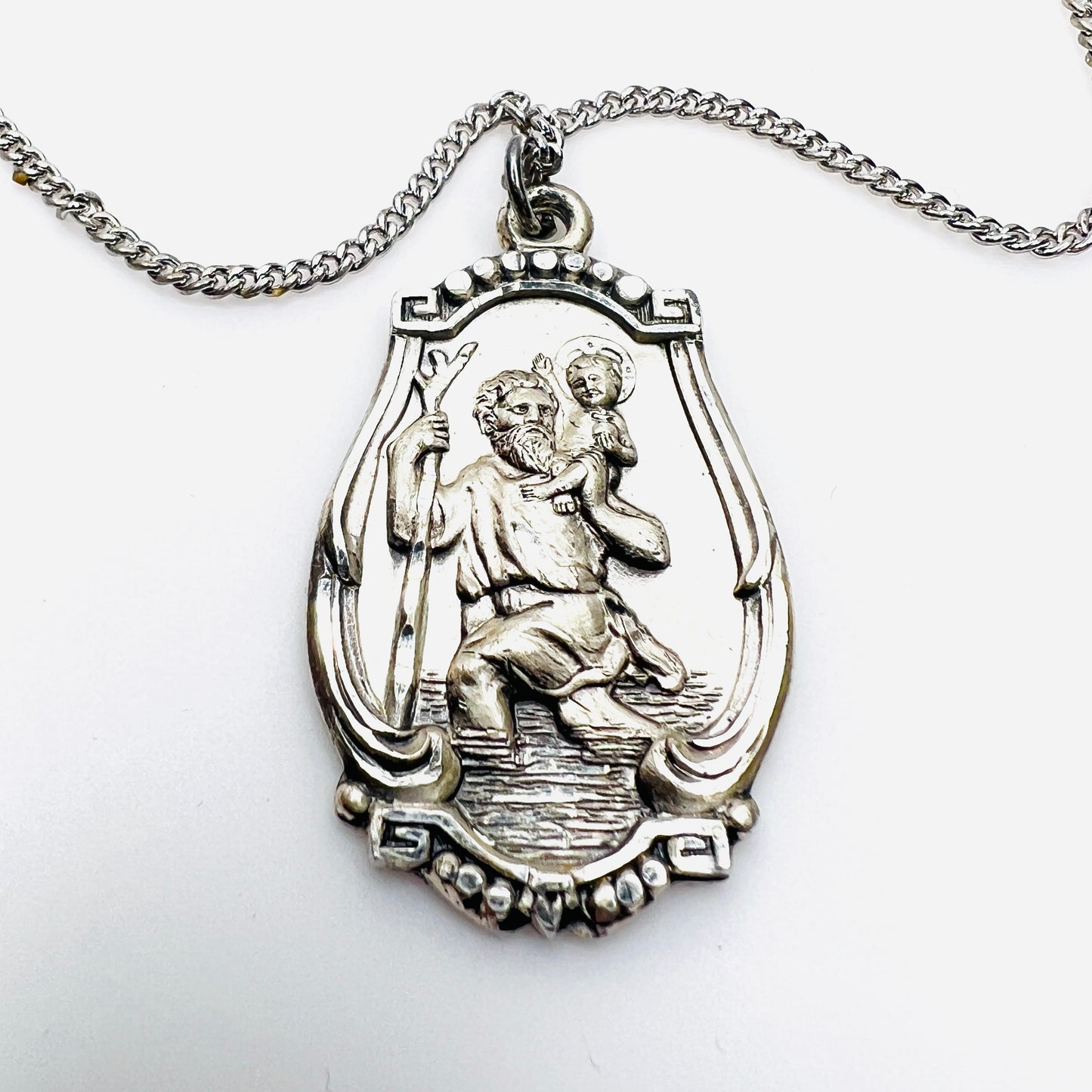 Close-up of vintage sterling silver St. Christopher religious medal pendant.
