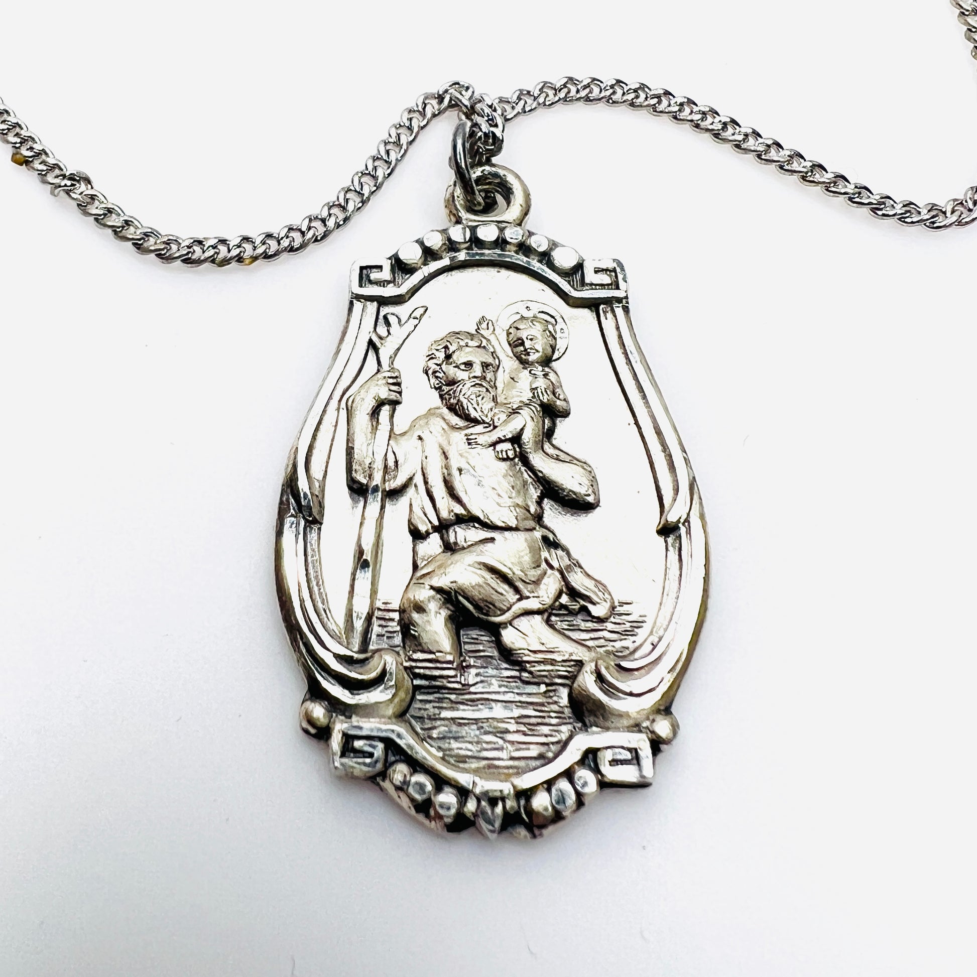 Close-up of vintage sterling silver St. Christopher religious medal pendant.