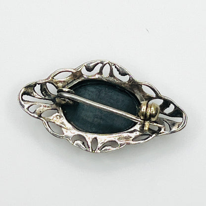 Reverse of vintage sterling silver black onyx brooch showing openwork construction and rollover pin clasp.