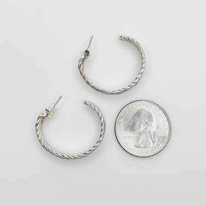 Sterling silver hoop earrings beside quarter for size reference