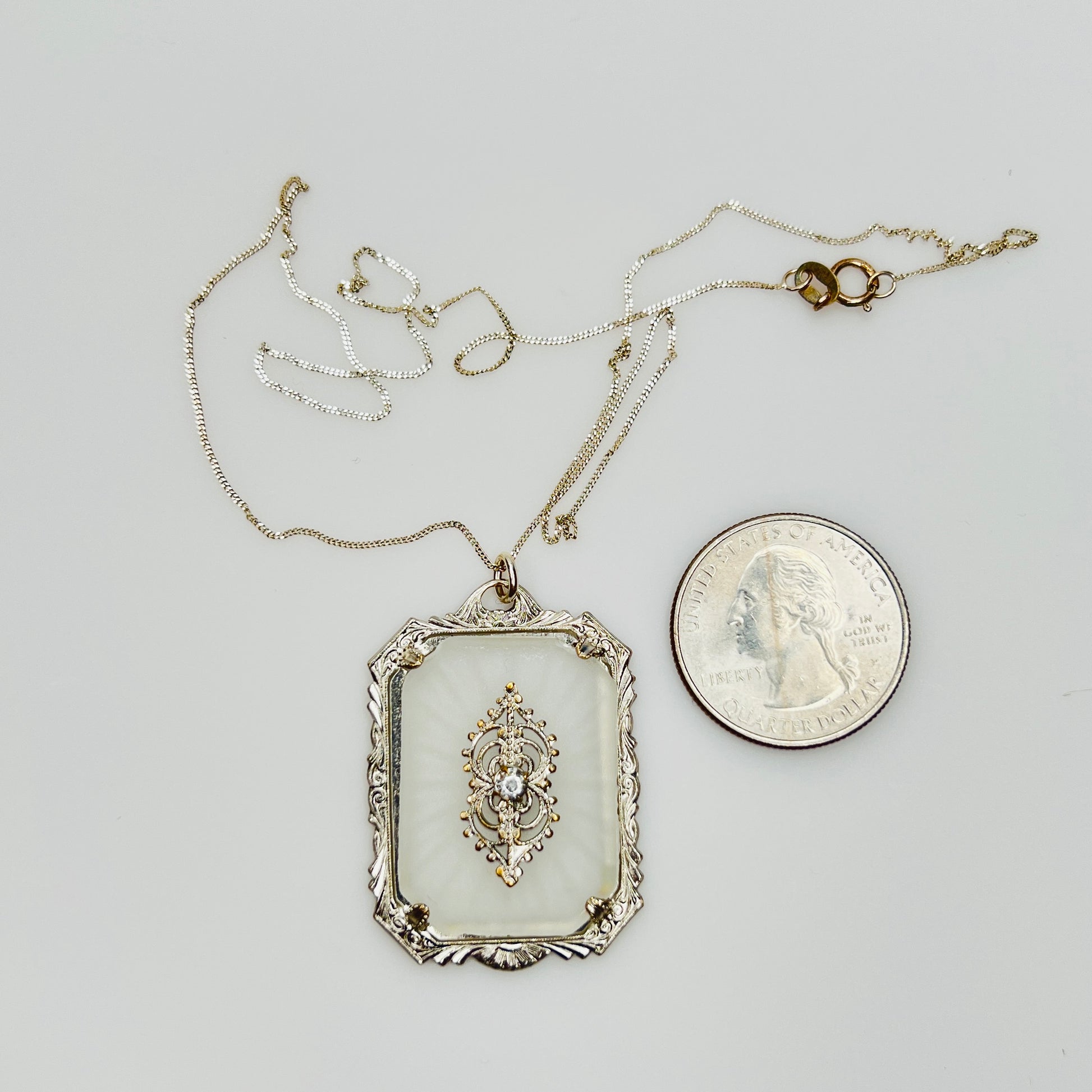 Pendant with quarter for size reference on silver chain
