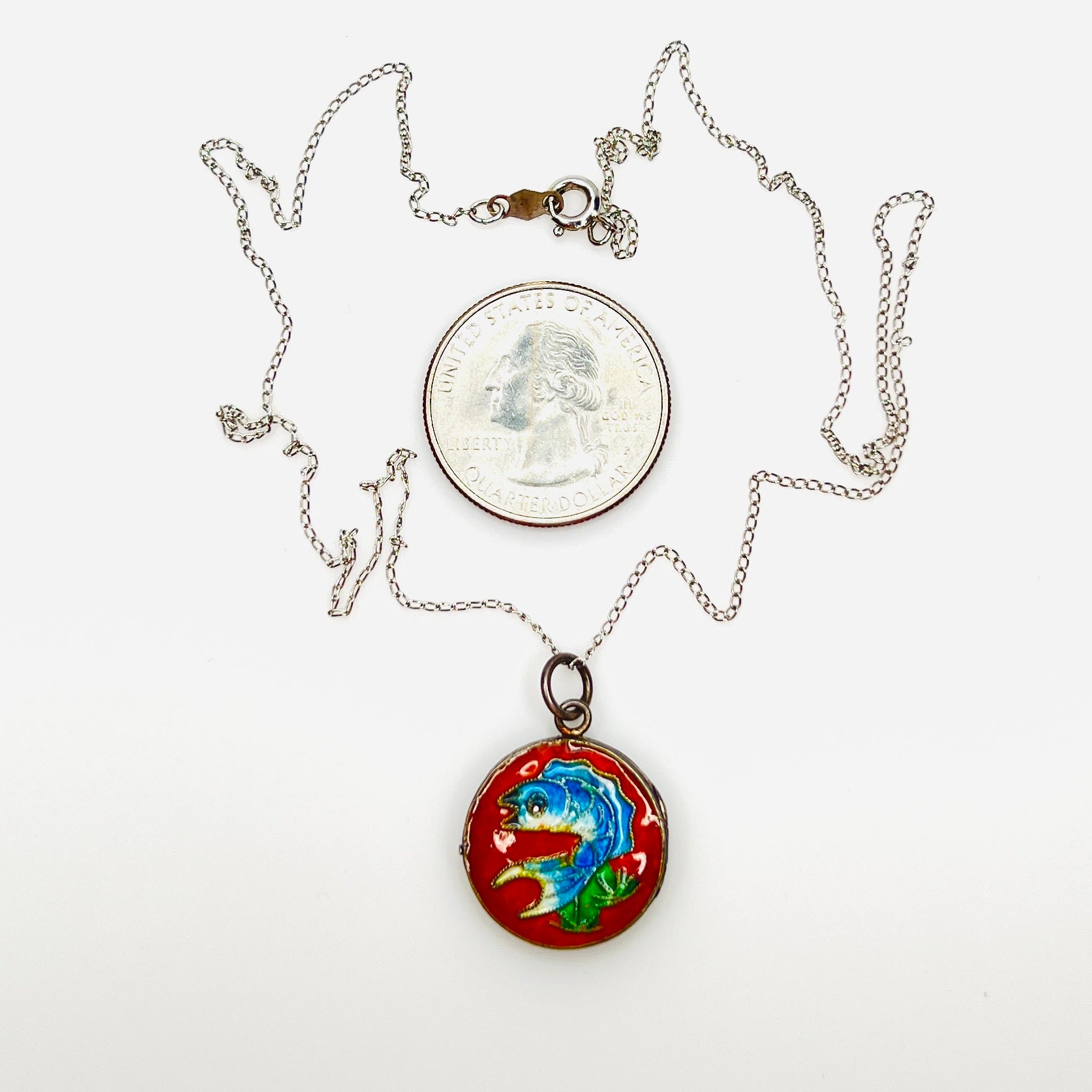 Cloisonné koi fish sterling silver photo locket beside quarter for scale.