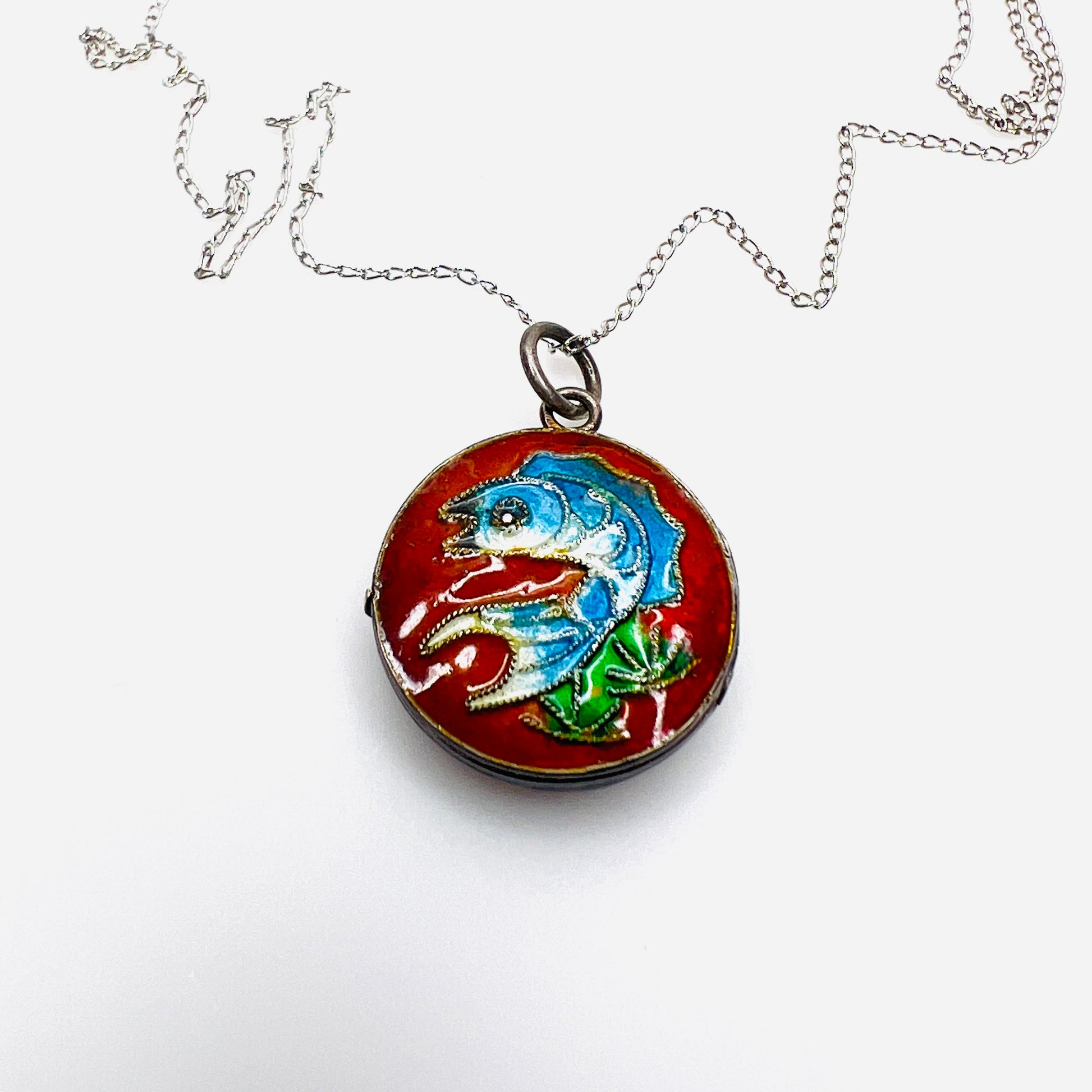 Close-up of vintage sterling silver cloisonné koi fish enamel locket.