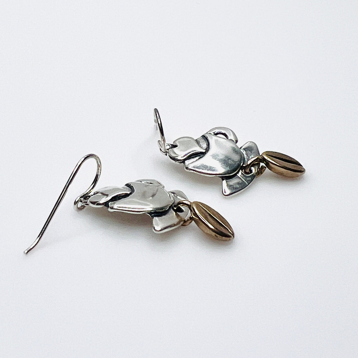 Side view of vintage silver coffee cup earrings with dimensional bean dangles