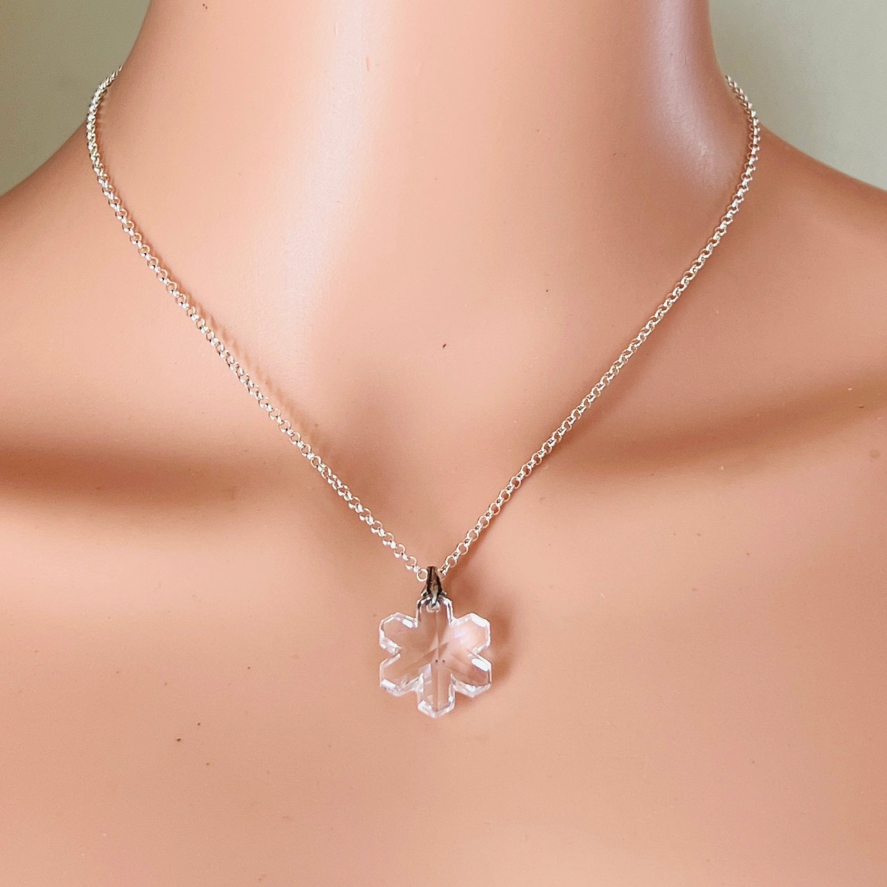 Snowflake crystal pendant worn on neckline with delicate silver chain