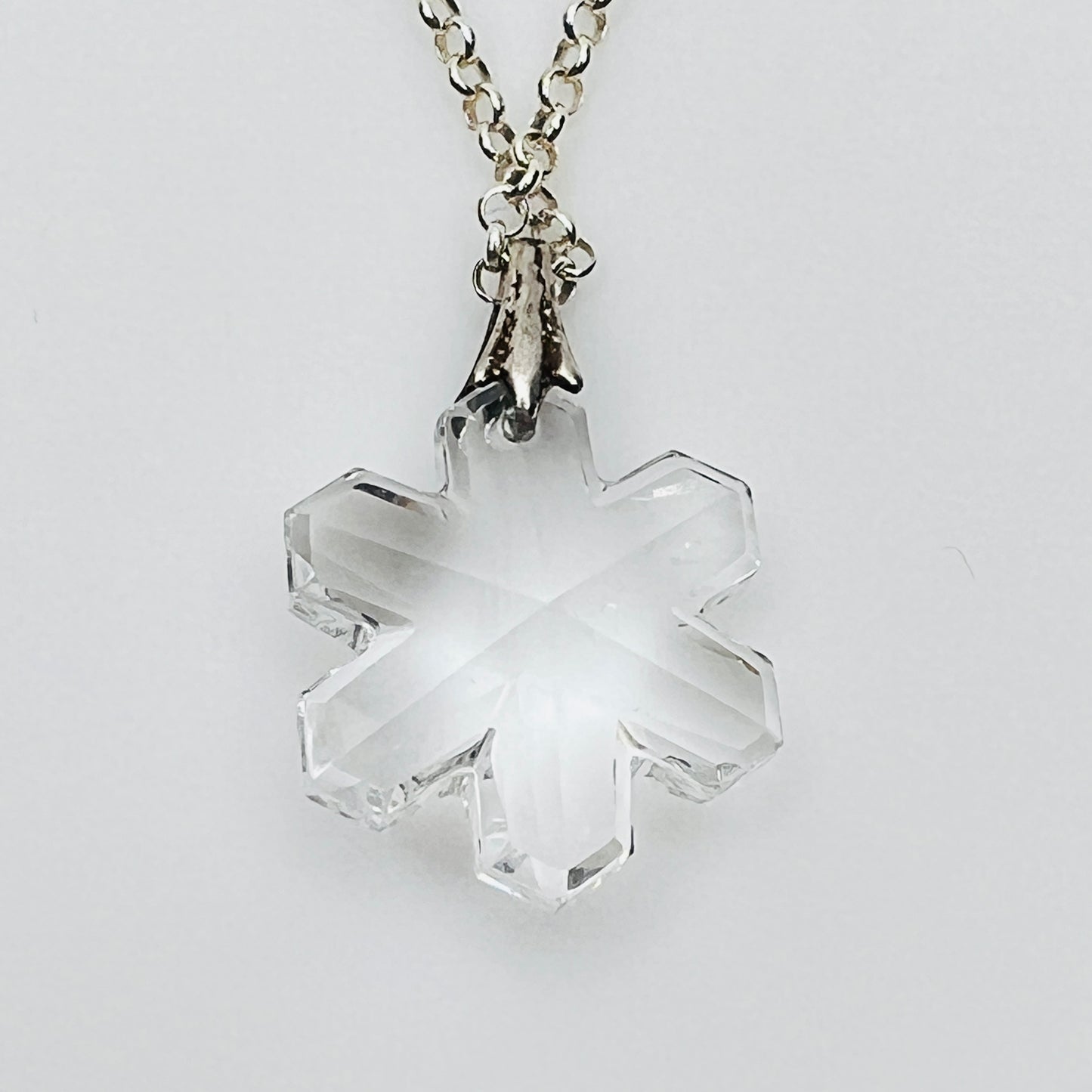 Close-up of faceted crystal snowflake pendant on silver bail