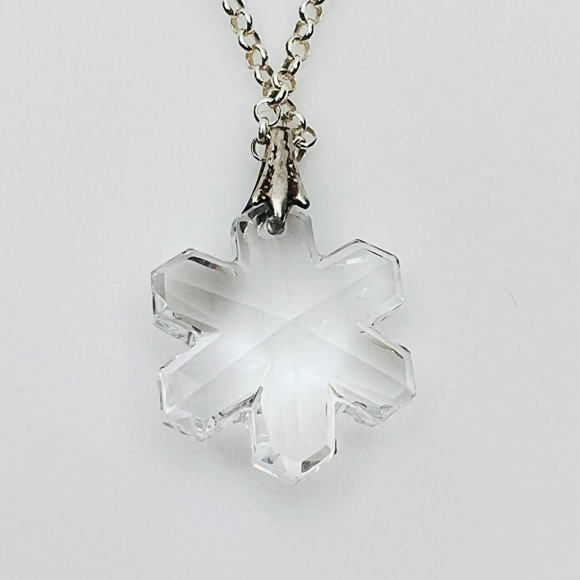Close-up of faceted crystal snowflake pendant on silver bail