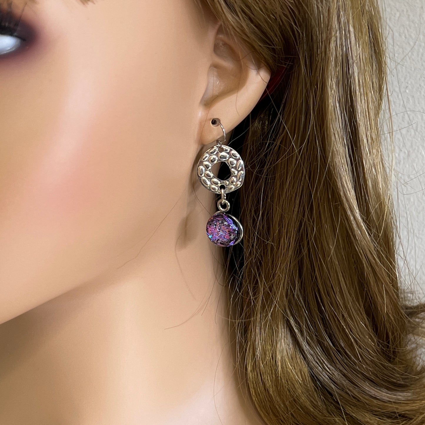 Artisan dangle earrings worn on ear