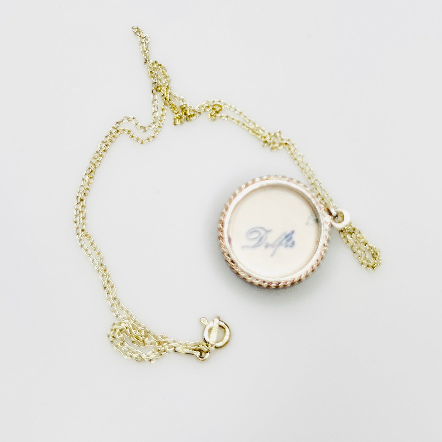 Back of Delft porcelain pendant stamped Delfts in sterling silver setting
