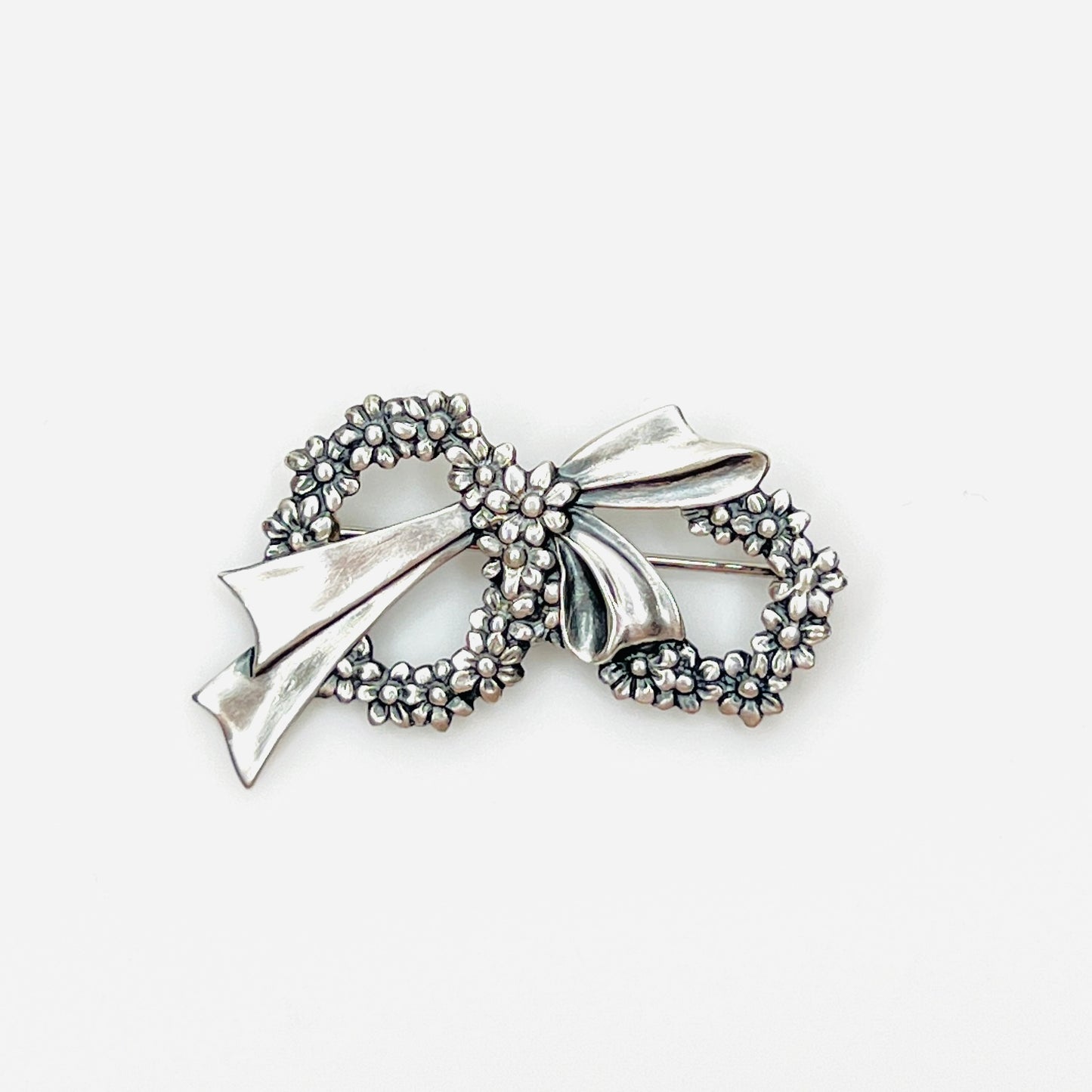 Vintage sterling silver floral wreath bow brooch with detailed daisy flowers, circa 1960s.