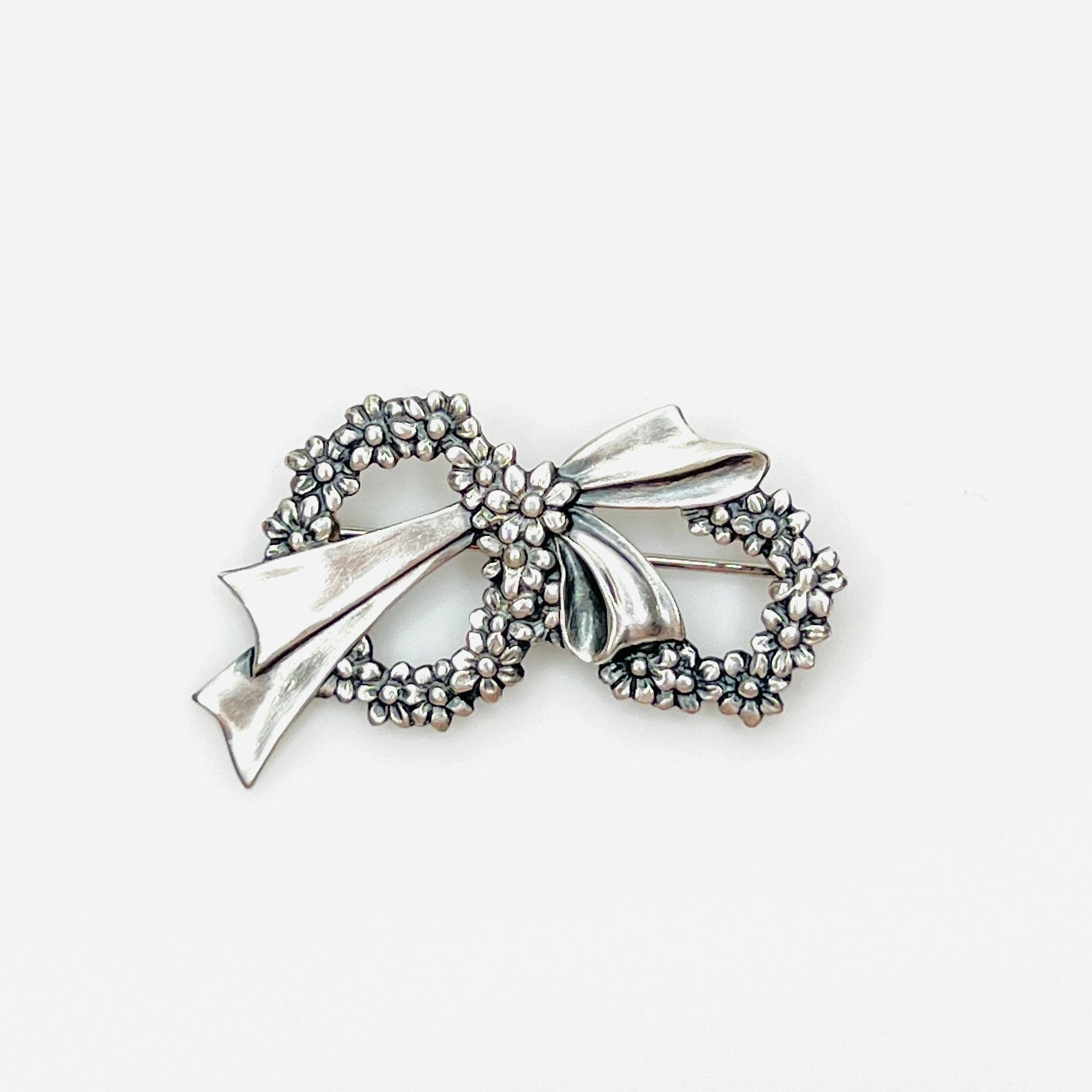 Vintage sterling silver floral wreath bow brooch with detailed daisy flowers, circa 1960s.