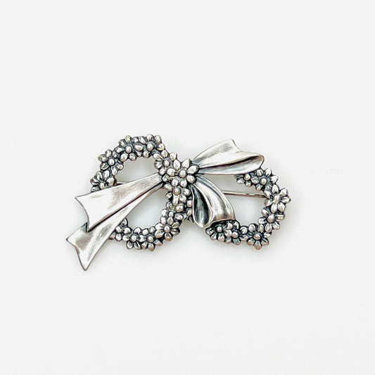 Vintage sterling silver floral wreath bow brooch with detailed daisy flowers, circa 1960s.
