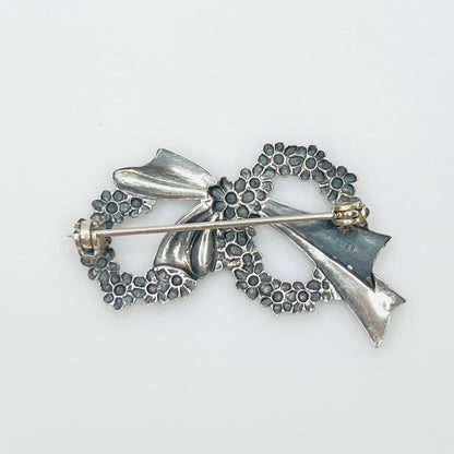 Reverse of vintage sterling silver floral wreath brooch showing pin clasp and sterling mark.