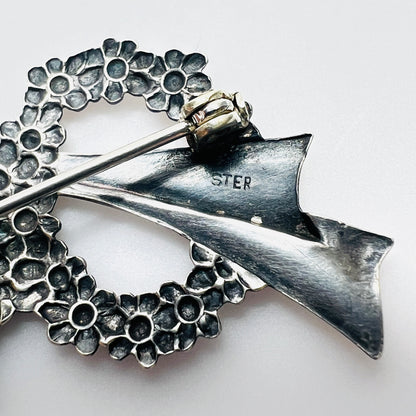 Close-up of sterling stamp on vintage sterling silver floral wreath bow brooch.