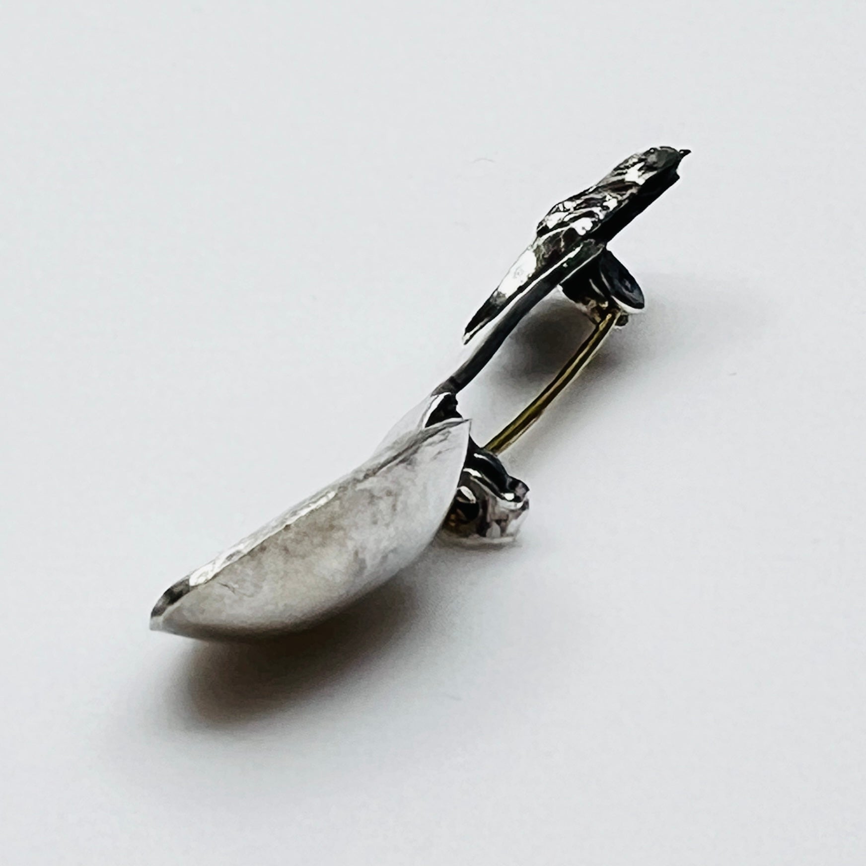 Side view of vintage spoon brooch with helmeted figure