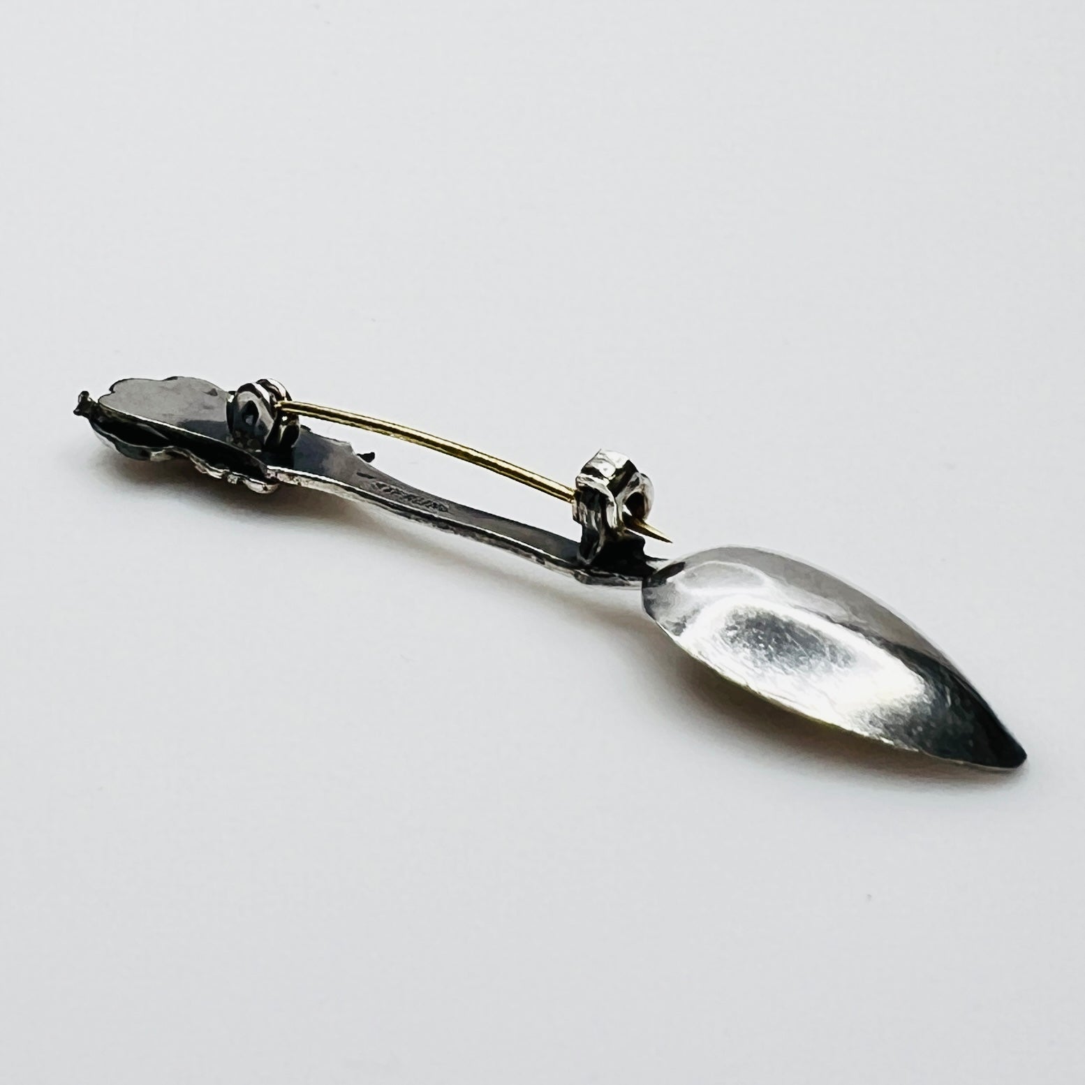Side view of vintage spoon brooch with helmeted figure