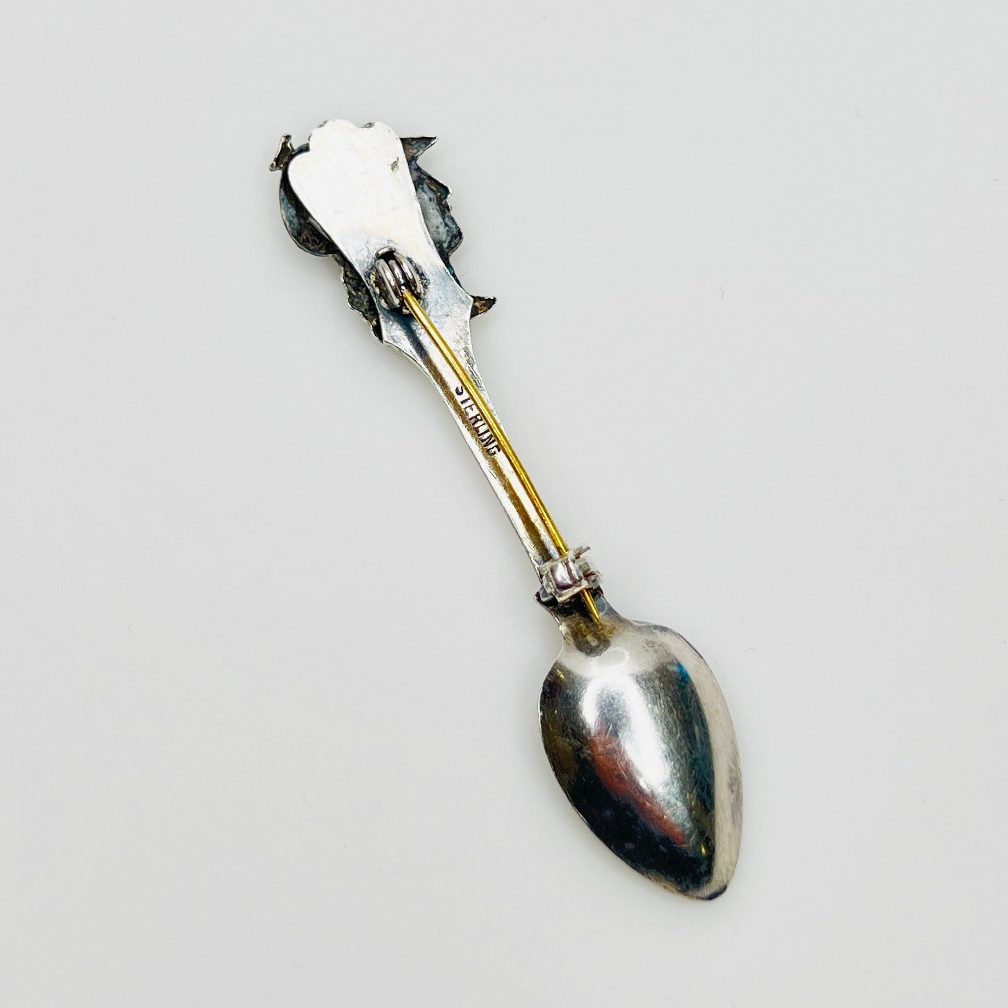 Back of sterling silver brooch showing clasp and stamp