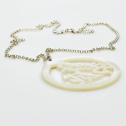 Side profile of carved Mother of Pearl longevity pendant on sterling silver chain.