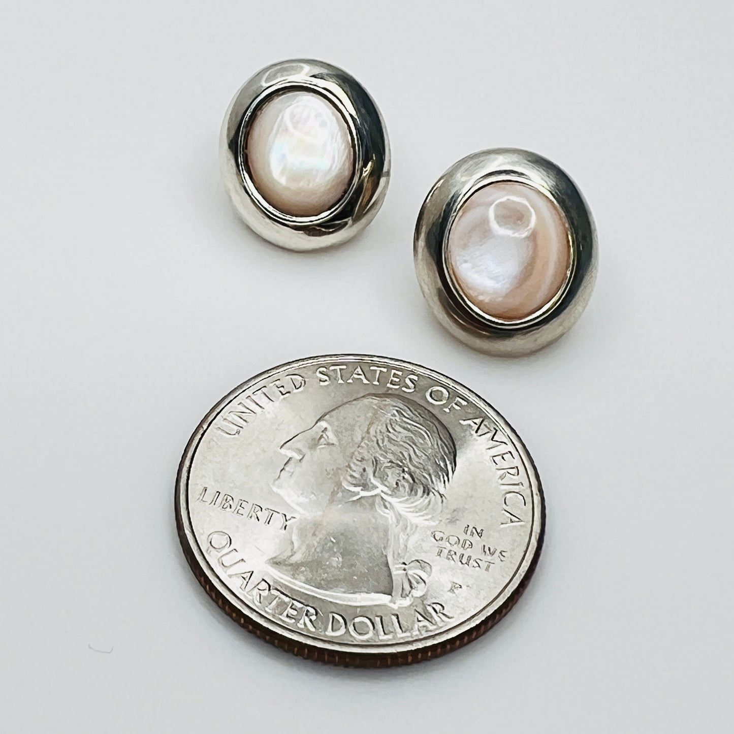 Vintage pearl stud earrings with US quarter for size comparison