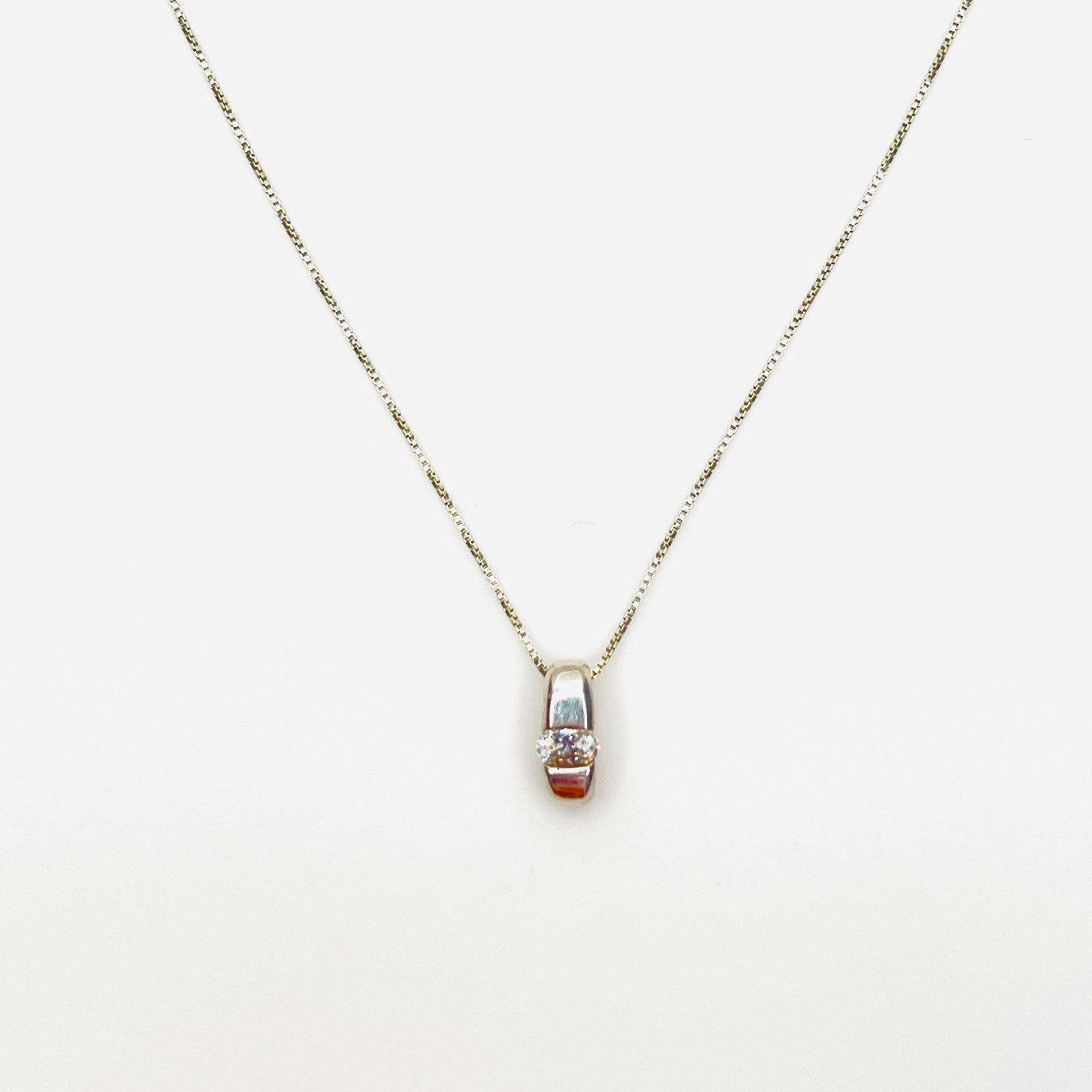 Vintage sterling silver pendant necklace with oval channel-set cubic zirconia solitaire.