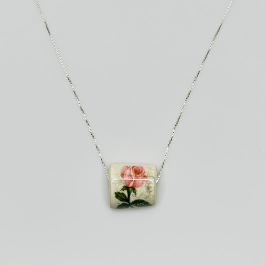 Close-up of pink rose tile pendant with crackle glaze detail