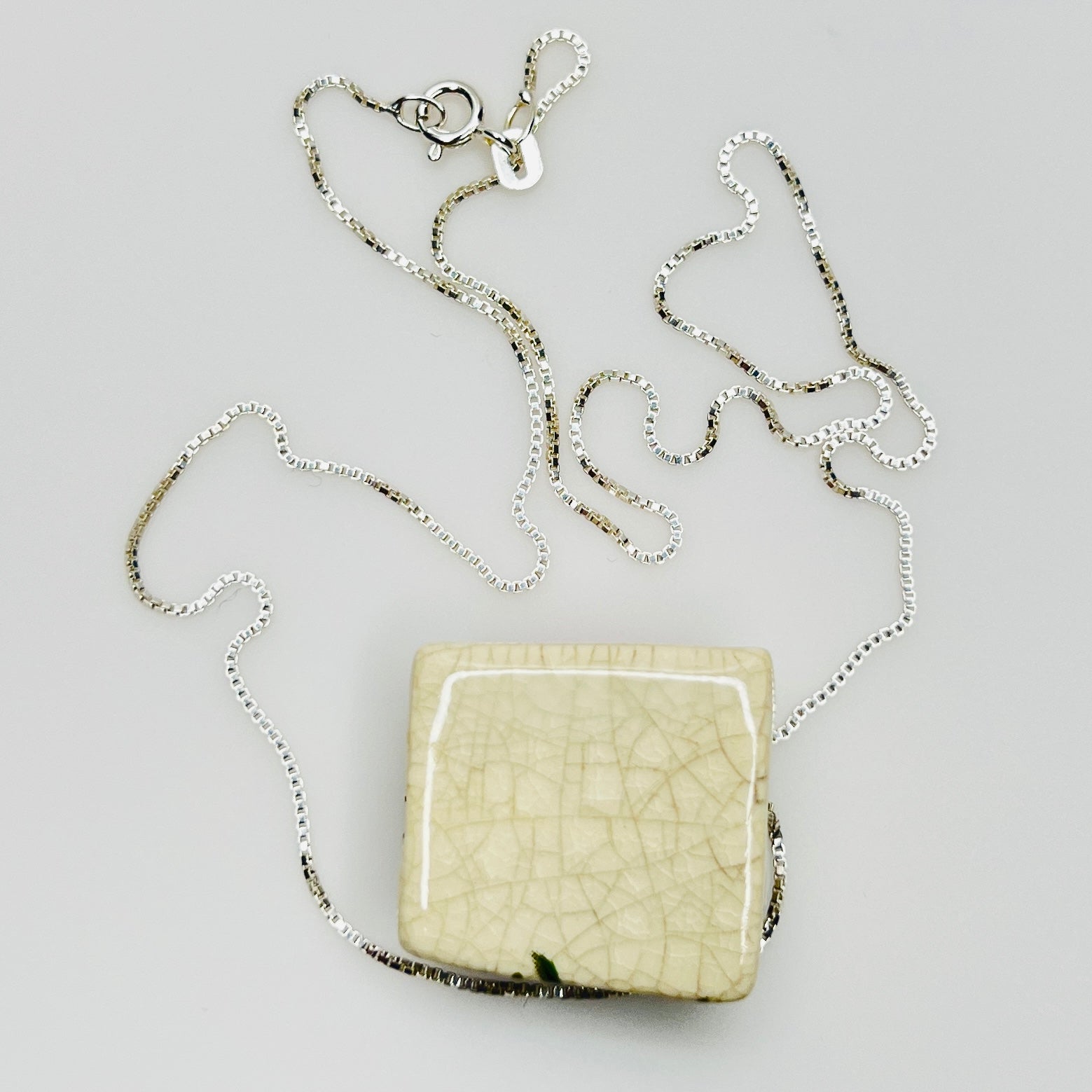 Back of ceramic pendant with ivory crackled glaze and chain