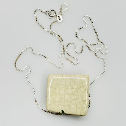 Back of ceramic pendant with ivory crackled glaze and chain