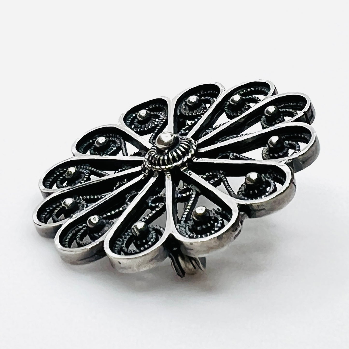 Side profile of vintage sterling silver openwork pinwheel brooch.