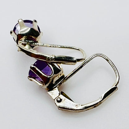 Close-up sterling silver prong set purple topaz earrings