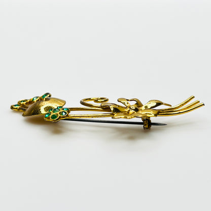 Side view of dimensional vermeil sterling floral brooch with green rhinestones