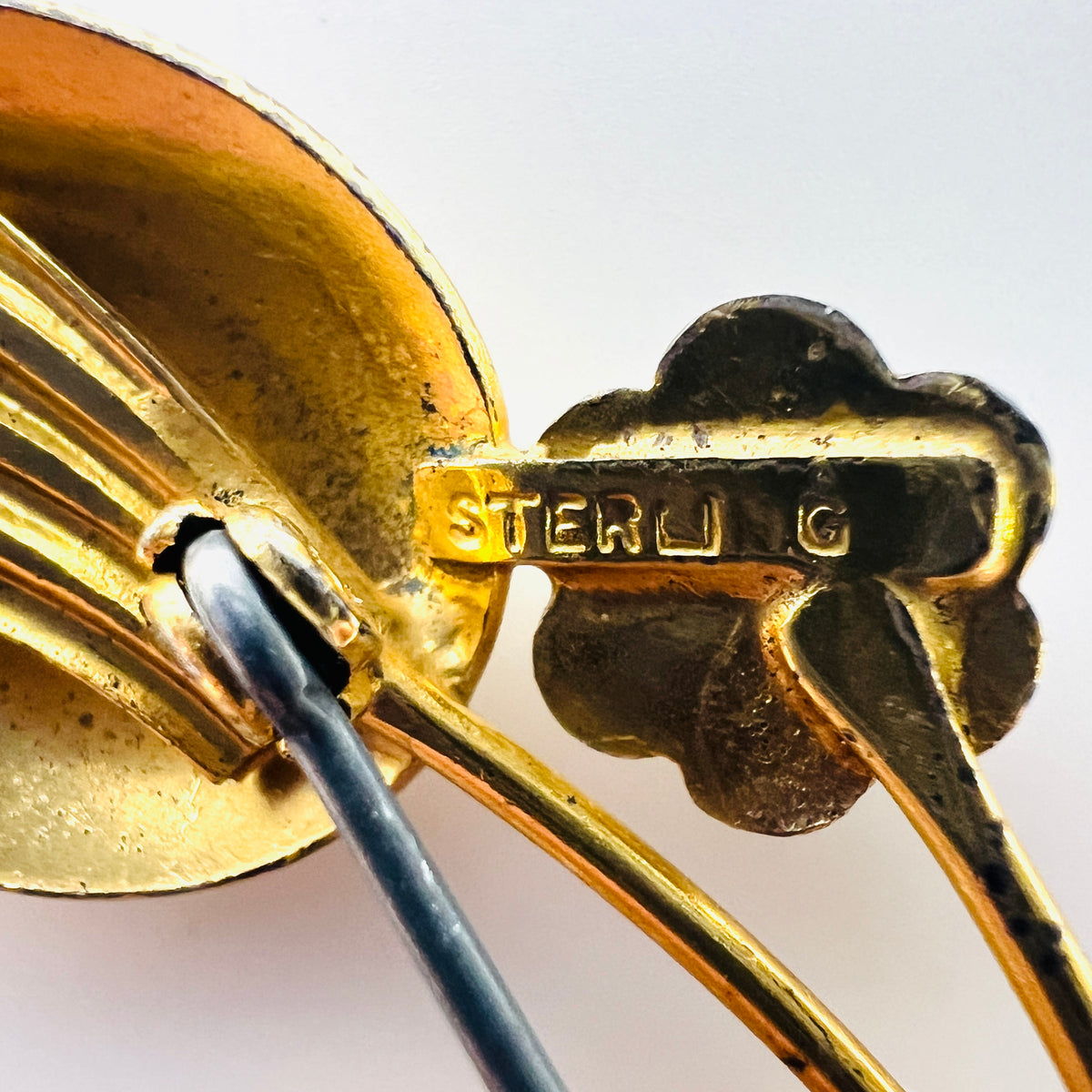 Close-up of STERLING stamp and vermeil finish wear on vintage flower brooch