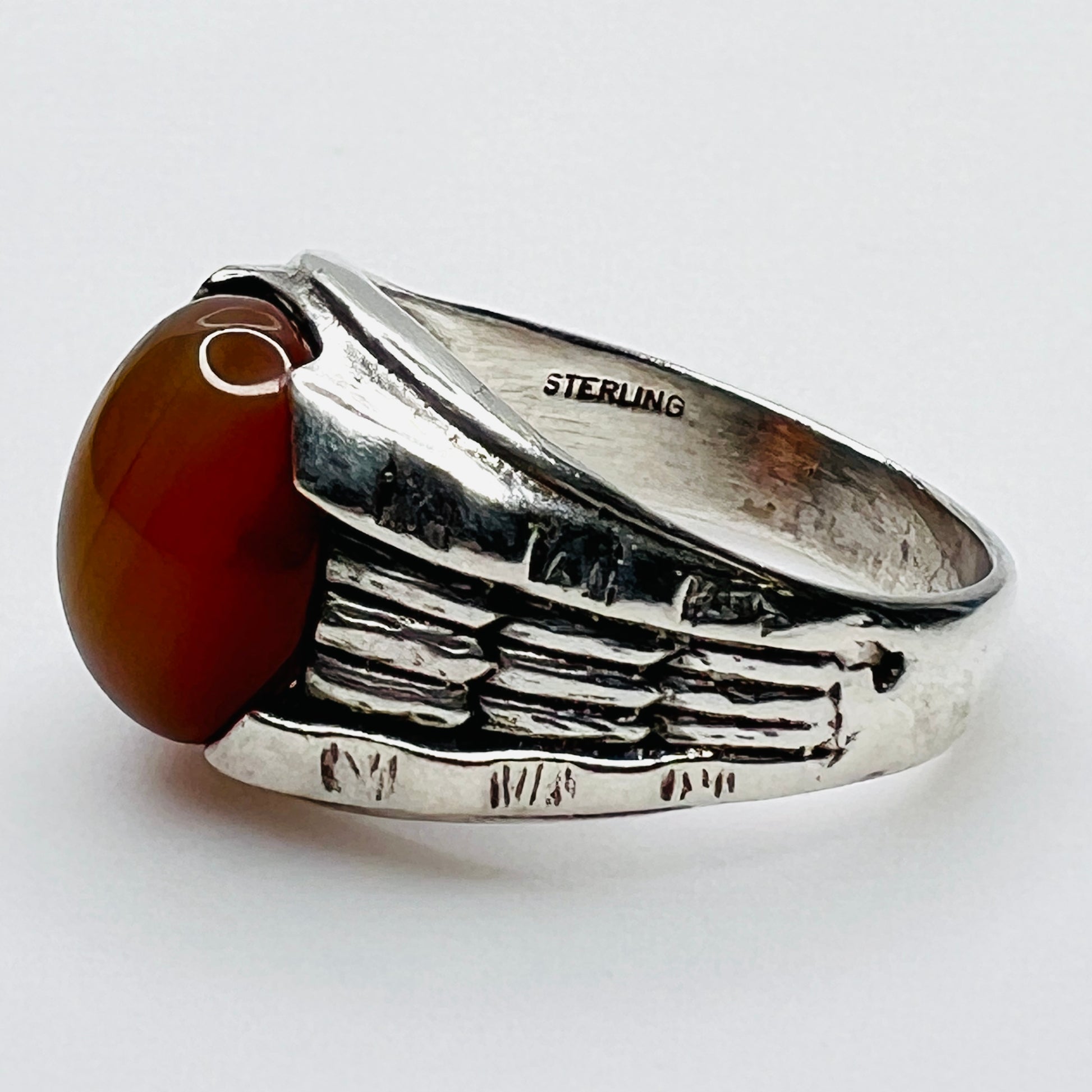 Side view of vintage sterling silver ring with orange carnelian cabochon and sterling stamp