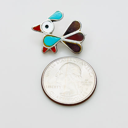 Small sterling silver inlay bird brooch pendant beside quarter for scale, turquoise and mother of pearl