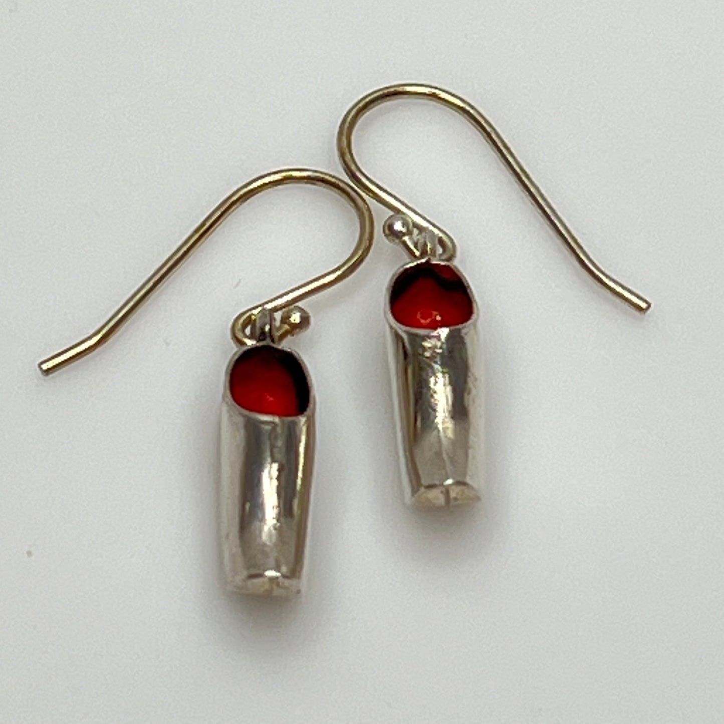 Top view of wooden shoe earrings showing red enamel interior and hook ear wires