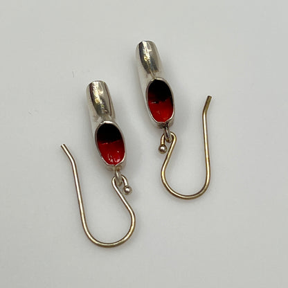 Top view of wooden shoe earrings showing red enamel interior and hook ear wires