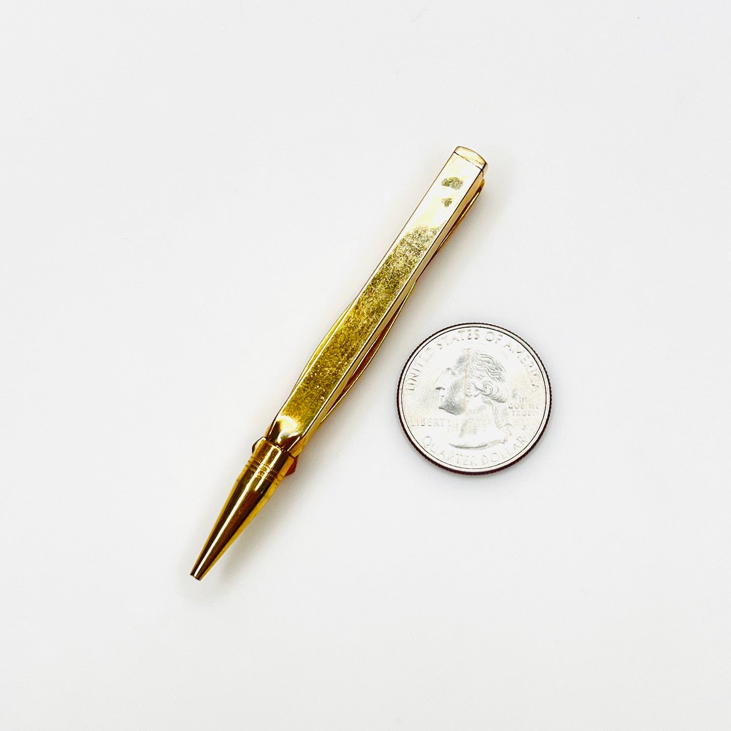 Swank gold tone pencil tie clip with quarter for size reference