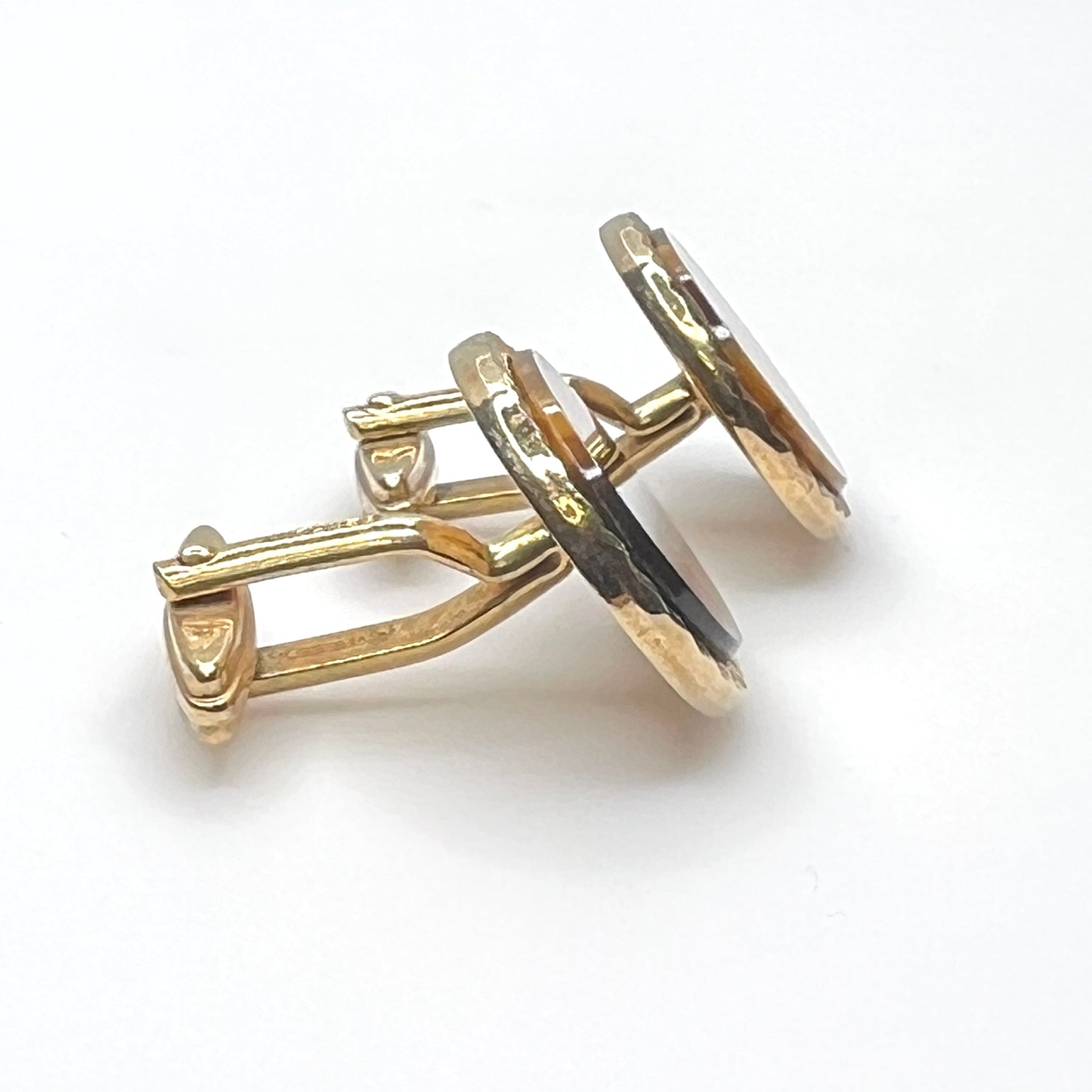 Side view of vintage tiger eye cufflinks with gold tone toggle backs